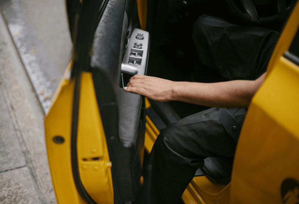 Alguien abriendo la puerta de un taxi o transfer para llegar y alojarse al Hotel Bernat II de Calella