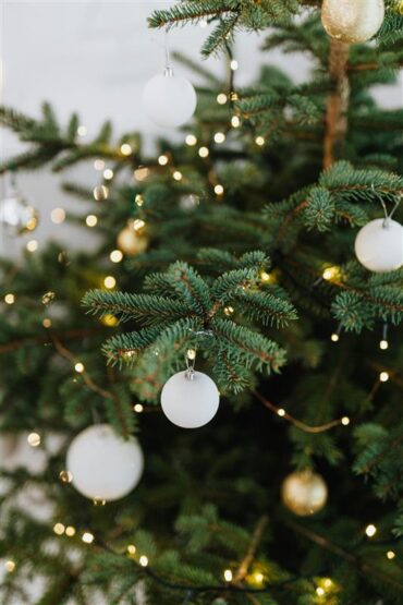 Árbol de Navidad con bolas blancas y luces cálidas para celebrar la Navidad en Calella